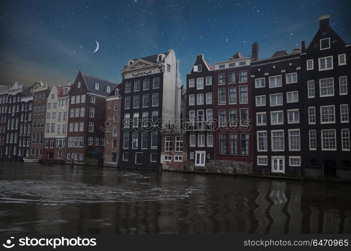 Traditional old buildings in Amsterdam, the Netherlands . night shining moon and stars.. Traditional old buildings in Amsterdam