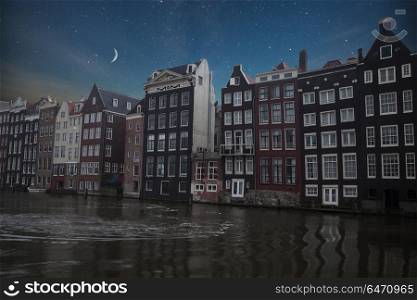 Traditional old buildings in Amsterdam, the Netherlands . night shining moon and stars.. Traditional old buildings in Amsterdam