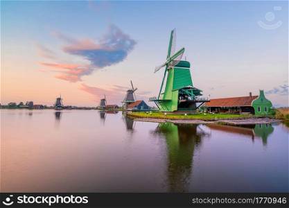 Traditional old village with dutch windmills in Amsterdam, Netherlands at sunset