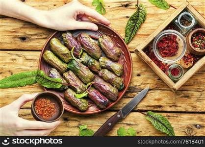 Traditional oriental dolma in grape leaves on rustic wooden table. Traditional Turkish dolma