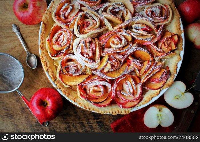 Traditional pie with apple shaped roses, fruit dessert, tart on wooden rustic table. Top view .. Traditional pie with apple shaped roses, fruit dessert, tart on wooden rustic table. Top view