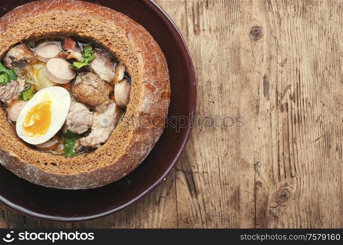 Traditional polish flour soup or zurek soup.Polish cuisine.Copy space.Rustic dish. Polish soup zurek in bread pot