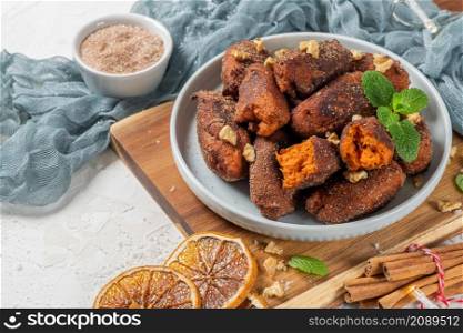 Traditional portuguese Christmas sweets named Bilharacos with sugar and cinnamon on kitchen countertop. This sweets are made with pumpkin. Is traditional in Aveiro region