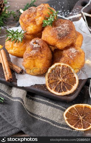 Traditional portuguese Christmas sweets Sonhos with sugar and cinnamon on kitchen countertop.