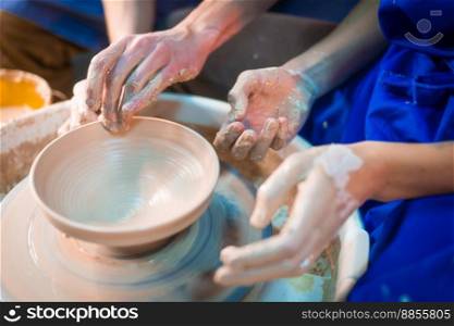 Traditional pottery making, man teacher shows the basics of pottery in art studio. Artist operates hands, which gently creating correctly shaped jug handmade from clay.. Traditional pottery making, man teacher shows the basics of pottery in art studio. Artist operates hands, which gently creating correctly shaped jug handmade from clay