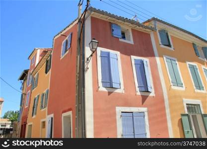 Traditional Provencal houses with plastered facades in bright colors in L&rsquo;Isle sur la Sorgue, France