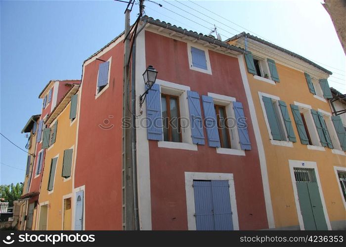 Traditional Provencal houses with plastered facades in bright colors in L&rsquo;Isle sur la Sorgue