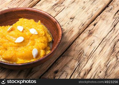 Traditional pumpkin porridge. Pumpkin porridge in a pottery on a retro background. Vegetarian food