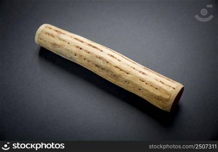 Traditional rain stick made of cactus wood isolated on black background. Traditional rain stick made of cactus wood isolated on black