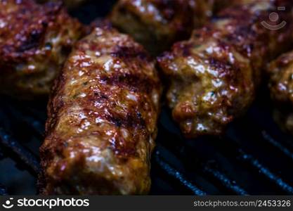 "Traditional Romanian food Meat Balls "mici" on grill. Tasty meat balls on barbeque, pork meat on charcoal barbecue"