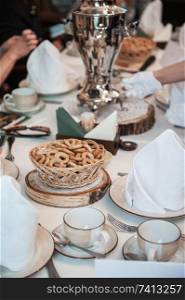 Traditional russian baked goods  pies and pretzels, samovar, honey, jam on the served table. Traditional russian baked goods