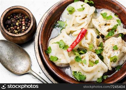 Traditional Russian dish pelmeni.Meat dumplings on rustic background. Oriental dumplings with minced meat