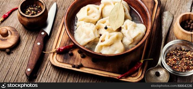 Traditional Russian dish pelmeni.Meat dumplings on wooden rustic background. Dumplings with meat