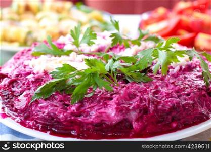 traditional Russian herring salad garnished with leaves of green
