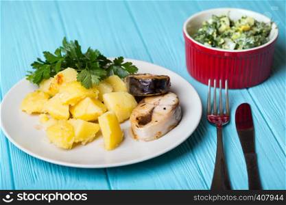 traditional Scandinavian dinner - boiled potatoes and mackerel on a blue background