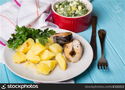 traditional Scandinavian dinner - boiled potatoes and mackerel on a blue background