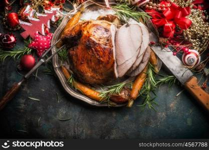 Traditional sliced roasted glazed Christmas ham with holiday festive decoration on dark rustic background, top view, border