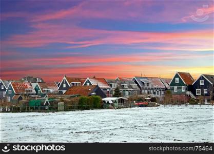 Traditional snowy houses in Marken the Netherlands at sunset