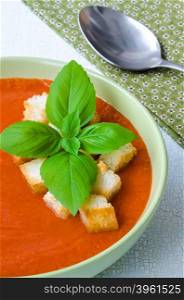 Traditional Spanish cold tomato soup gazpacho with basil and croutons. Traditional Spanish cold tomato soup gazpacho with basil and croutons on wooden table