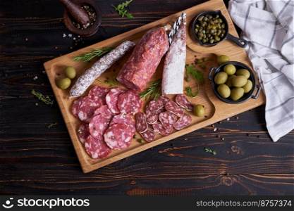 Traditional Spanish fuet salami sausage on wooden cutting board at domestic kitchen.. Traditional Spanish fuet salami sausage on wooden cutting board at domestic kitchen
