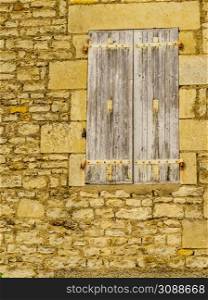 Traditional stone building with old wooden shutter window, France.. Stone building with shutters window, France