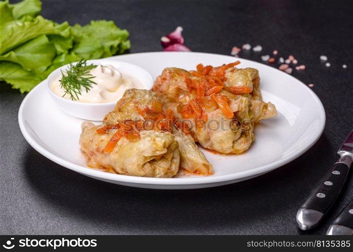 Traditional stuffed cabbage with minced meat and rice, served in a tomato sauce. Cabbage rolls stuffed with ground beef and rice served on a white plate