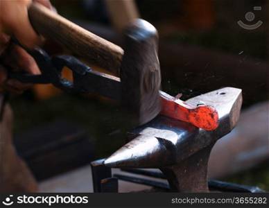 Traditional style blacksmith at work. Hammer hands and iron.
