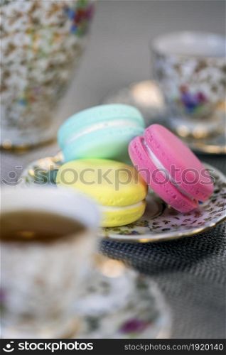 Traditional table with cup of tea and tea pot and colorful macaron lovely cozy table at home,Mother&rsquo;s Day tea setting with teapot, close up. Traditional table with cup of tea and tea pot and colorful macaron lovely cozy table at home,Mother&rsquo;s Day tea setting with teapot,