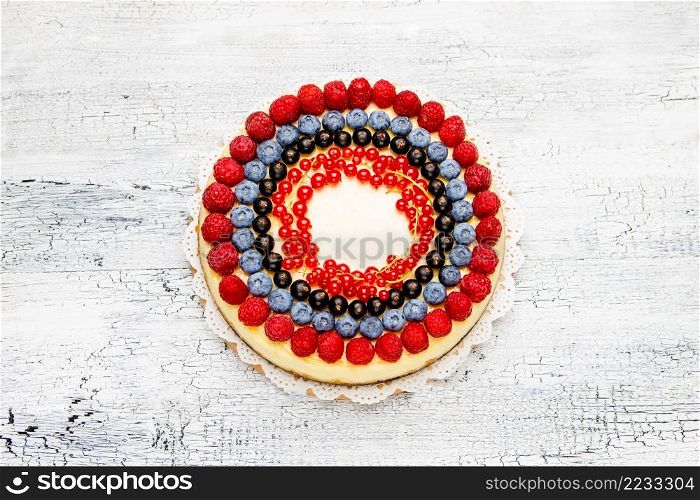 Traditional tasty raspberry and blueberry cheesecake on wooden table. Raspberry and blueberry cheesecake on wooden table