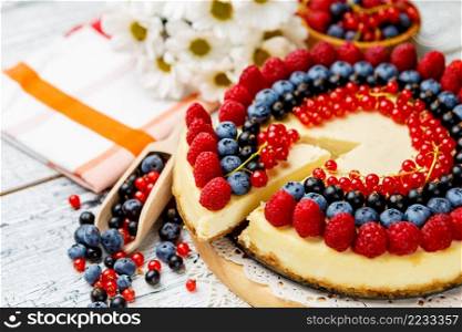 Traditional tasty raspberry and blueberry cheesecake on wooden table. Raspberry and blueberry cheesecake on wooden table