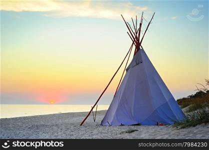 Traditional Teepee on a sea beach at beautiful sunset