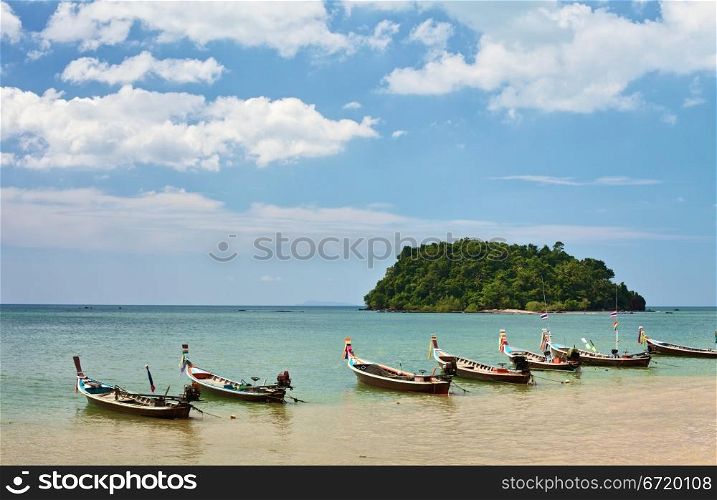 traditional thai long boats on beach in Thailand