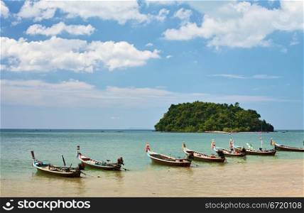 traditional thai long boats on beach in Thailand