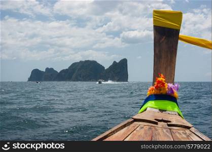 Traditional Thai Longtail boat and island of Phi Phi Leh on the horizon,Thailand