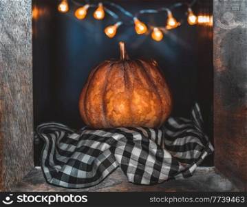 Traditional Thanksgiving Day Decor. Big Ripe Orange Pumpkin Decorated with Glowing Garland. Beautiful Festive Still Life. Cozy Family Evening.. Happy Thanksgiving Day
