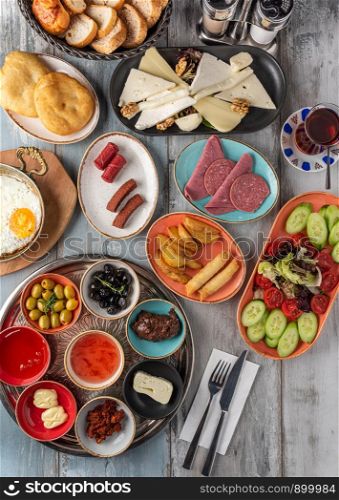 Traditional Turkish Breakfast served with traditional turkish tea on wooden table