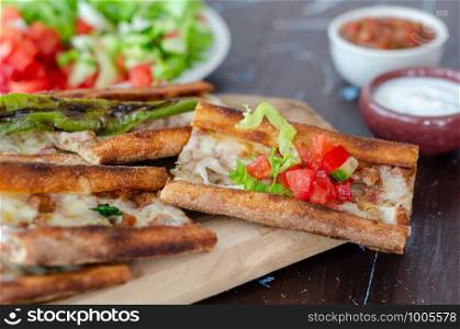 Traditional Turkish cuisine : Pita(pide) with minced meat and cheese, close up.