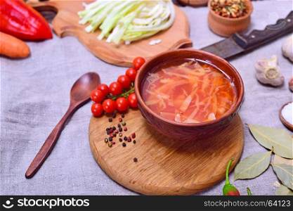 Traditional Ukrainian borsch in a round brown plate, view from above