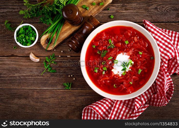 Traditional ukrainian borscht, vegetable soup with tomato, beet, carrot, potato, pepper, cabbage and fresh greens, beetroot soup. Healthy vegetarian food