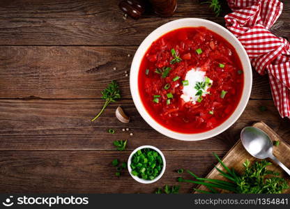 Traditional ukrainian borscht, vegetable soup with tomato, beet, carrot, potato, pepper, cabbage and fresh greens, beetroot soup. Healthy vegetarian food