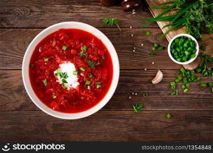 Traditional ukrainian borscht, vegetable soup with tomato, beet, carrot, potato, pepper, cabbage and fresh greens, beetroot soup. Healthy vegetarian food