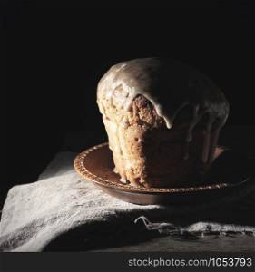 traditional Ukrainian Easter pastry lies on a gray linen towel, black background