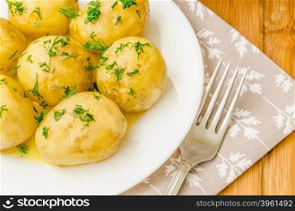 Traditional Ukrainian food boiled new potatoes with butter and dill. Traditional Ukrainian food boiled new potatoes with butter and dill on wooden table