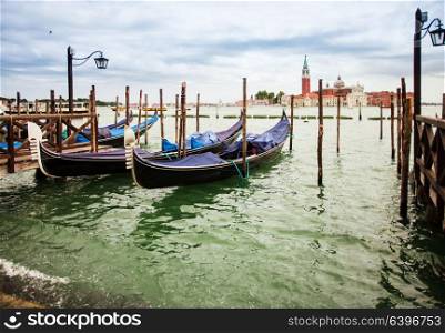 Traditional view from San Marco, Venice, Italy. Blue gondolas parked on Canal Grande, San Giorgio Maggiore church at the background. San Marco, Venice, Italy