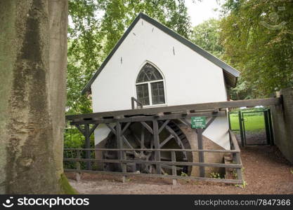 Traditional water mill with impeller in forest scenery