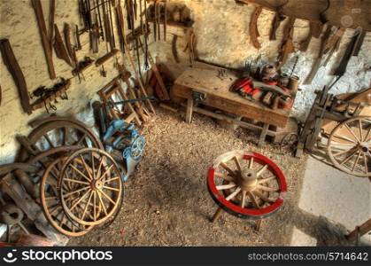 Traditional wheelwrights workshop with tools and cartwheels, England.