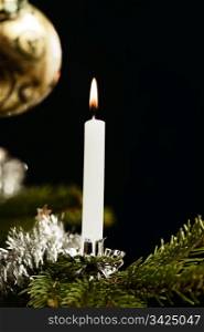 Traditional white candle on Christmas tree, retro look like.