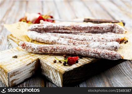 Traditional white salami sausage, sliced salami isolated on white background. Whole dry salami sausage stick.