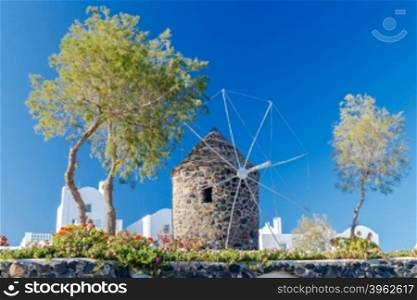 Traditional windmill on the Greek island Santorini on the background of blue sky.. Oia. Traditional stone windmill.