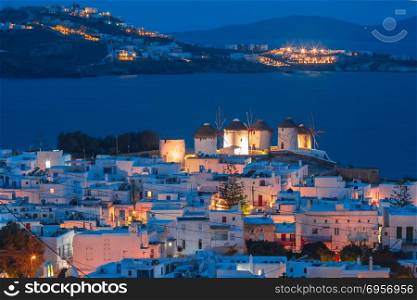 Traditional windmills at sunset, Santorini, Greece. Aerial view with traditional windmills on the island Mykonos, The island of the winds, during evening blue hour, Greece